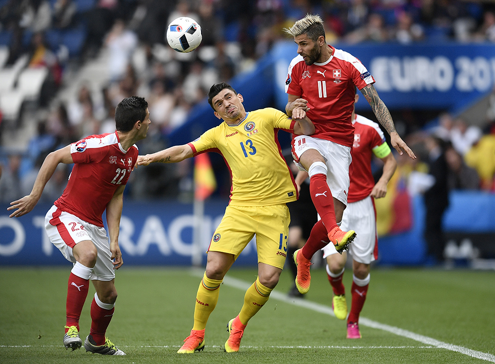Switzerland's Valon Behrami, right, jumps for the ball with Romania's Claudiu Keseru during the Euro 2016 Group A soccer match between Romania and Switzerland at the Parc des Princes stadium in Paris, France, Wednesday, June 15, 2016. (AP Photo/Martin Meissner)